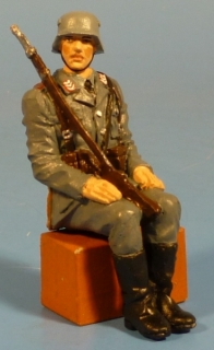 Soldat sitzend mit Gewehr