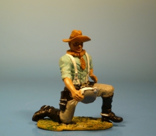 Cowboy kniend mit Feldflasche