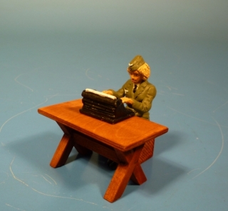 Nachrichtenhelferin sitzend am Tisch mit Schreibmaschine